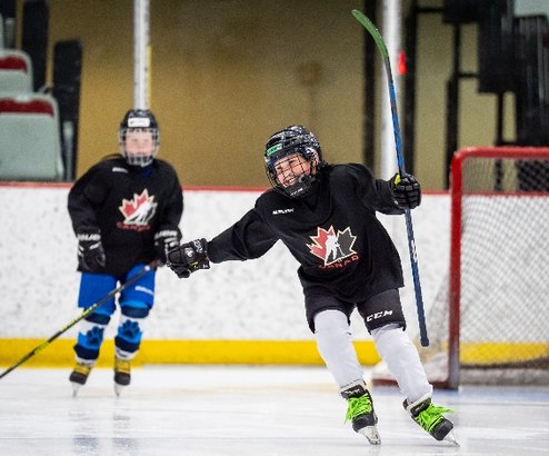 Two young players skating during a small-area game